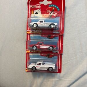 Three vintage Coca Cola cars